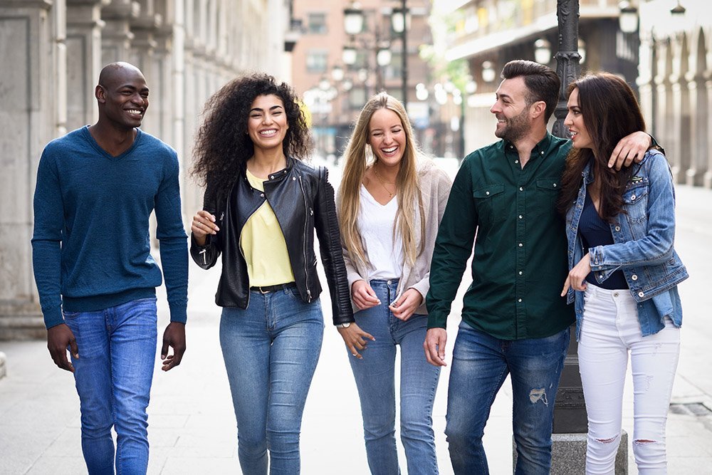 Group of friends having fun together outdoors Multi-ethnic group of young people having fun together outdoors in urban background. group of people walking together