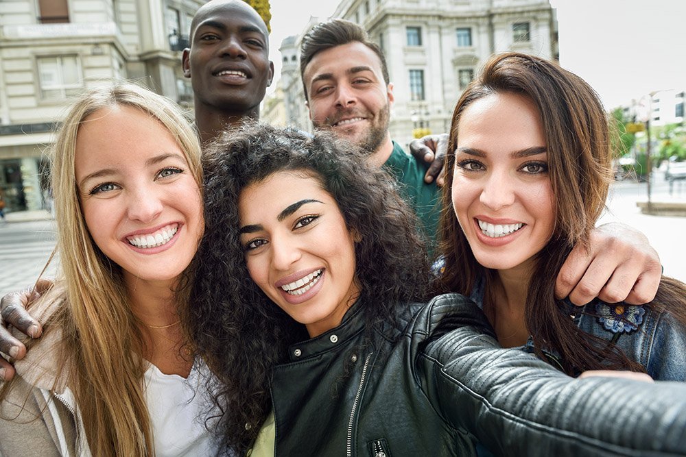 Multiracial group of young people taking selfie Multiracial group of friends taking selfie in a urban street.
