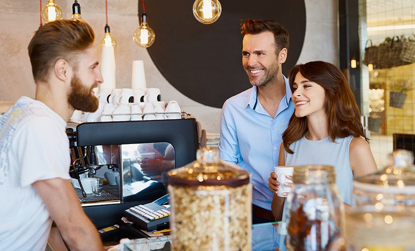 Couple at cafe talking barista, buying coffee collecting customer information on ipad